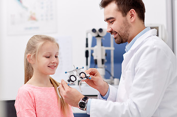 Image showing optician with trial frame and girl at clinic