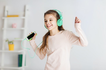 Image showing girl with smartphone and headphones at home