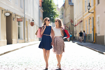 Image showing happy women with shopping bags walking in city