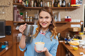 Image showing barista woman pouring cream to cup at coffee shop