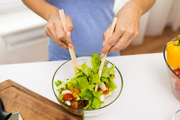 Image showing close up of woman cooking vegetable salad at home