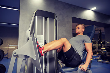 Image showing man flexing leg muscles on gym machine