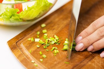 Image showing close up of woman chopping green onion with knife