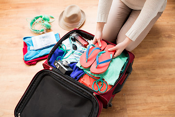 Image showing close up of woman packing travel bag for vacation