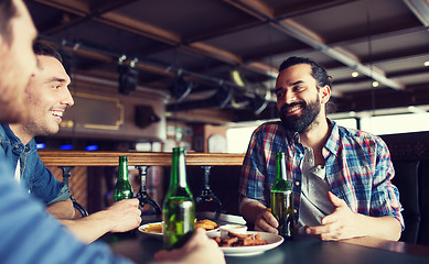 Image showing happy male friends drinking beer at bar or pub