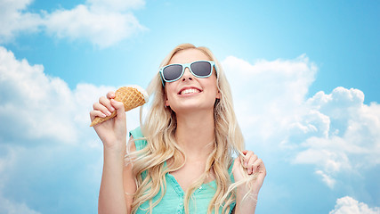 Image showing happy young woman in sunglasses eating ice cream