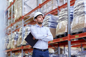 Image showing happy businessman with clipboard at warehouse