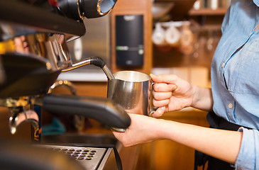 Image showing close up of woman making coffee by machine at cafe