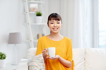 Image showing happy asian woman drinking from tea cup