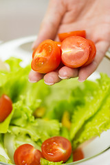 Image showing close up of woman cooking vegetable salad at home