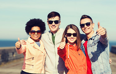 Image showing happy teenage friends in shades hugging outdoors