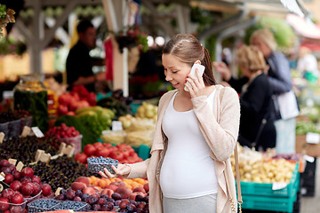 Image showing pregnant woman calling on smartphone at market