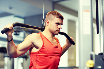 Image showing man flexing muscles on cable machine gym