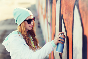 Image showing teenage girl drawing graffiti with spray paint