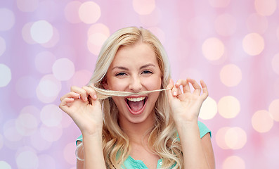 Image showing happy young woman making mustache with her hair