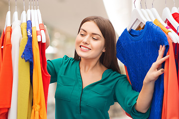 Image showing happy woman choosing clothes at home wardrobe