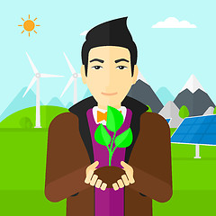 Image showing Man holding plant.