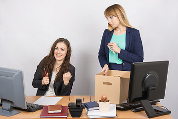 Image showing Office worker rejoices that dismissed colleague collects things