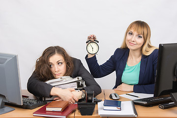 Image showing Two girls in the office at the end of the day, one positive, the other exhausted