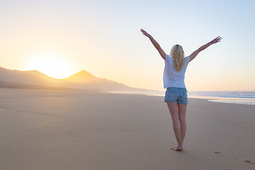 Image showing Free woman enjoying freedom on beach at sunrise.