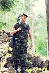 Image showing young soldier or hunter with gun in forest