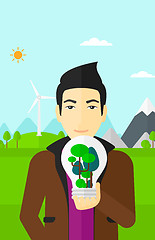 Image showing Man with lightbulb and trees inside.