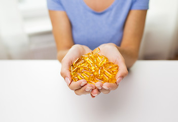 Image showing close up of woman hands holding pills or capsules