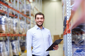 Image showing happy businessman with clipboard at warehouse