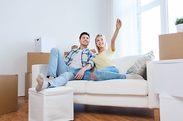 Image showing couple with boxes moving to new home and dreaming