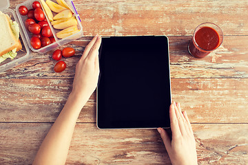 Image showing close up of woman with tablet pc food on table