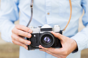 Image showing close up of hipster man with film camera in city