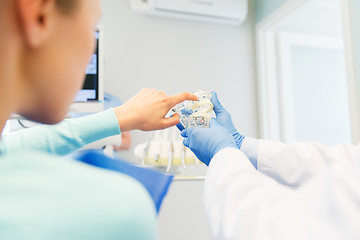 Image showing close up of dentist with teeth model and patient