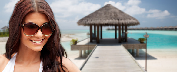 Image showing smiling young woman with sunglasses on beach