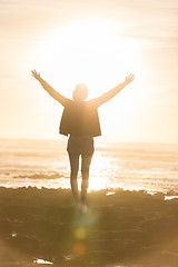 Image showing Free woman enjoying freedom on beach at sunset.