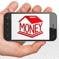 Image showing Money concept: Hand Holding Smartphone with Money Box on display
