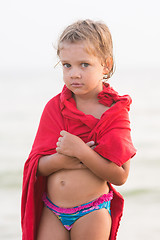 Image showing Sad frozen five year old girl wrapped herself in an adult t-shirt