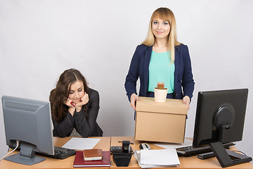 Image showing An employee in the office happily keeps things close sad colleague