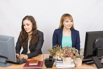 Image showing Two office employee, one of which workplace forced by plants