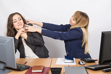 Image showing The girl in the office workplace trying to stifle a colleague