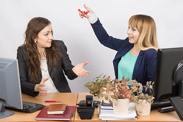 Image showing Office employee-grower sprinkles water from pulivizatora on irritated colleague