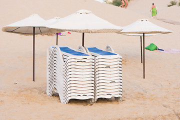 Image showing Collected in piles on the beach chairs under umbrellas