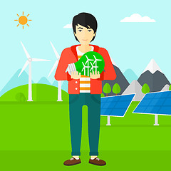 Image showing Man holding lightbulb with windmills inside.