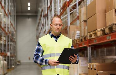 Image showing man with clipboard in safety vest at warehouse