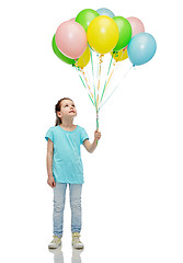 Image showing girl looking up with bunch of helium balloons