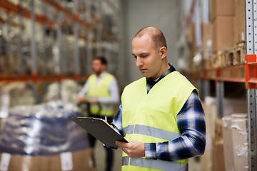 Image showing man with clipboard in safety vest at warehouse