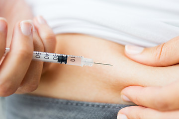 Image showing woman with syringe making insulin injection