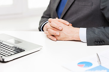 Image showing close up of businessman with laptop and papers