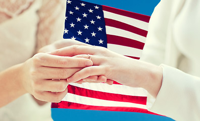 Image showing close up of lesbian couple hands with wedding ring