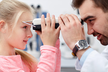 Image showing optician with pupilometer and patient at eye clinic