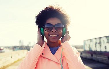 Image showing happy young woman in headphones listening to music